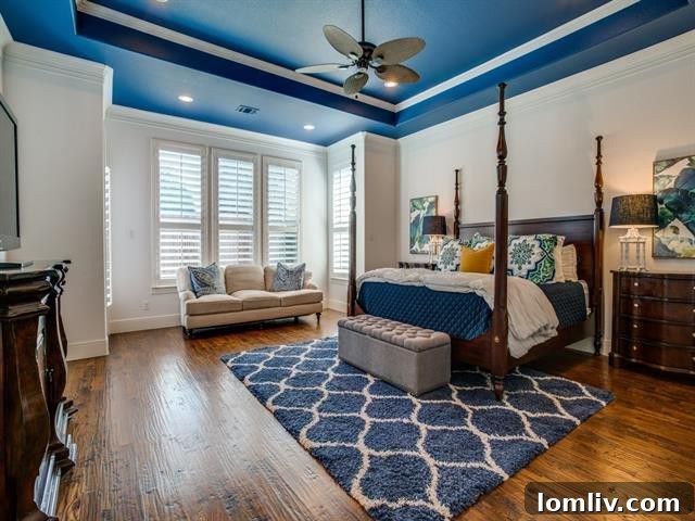 Master bedroom with an innovative blue painted ceiling and elegant decor in Frisco residence