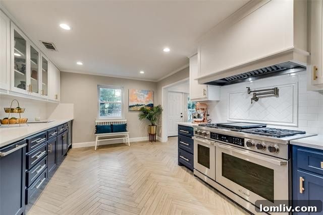 Stylish updated kitchen with navy and white cabinets, gold hardware, and quartz countertops