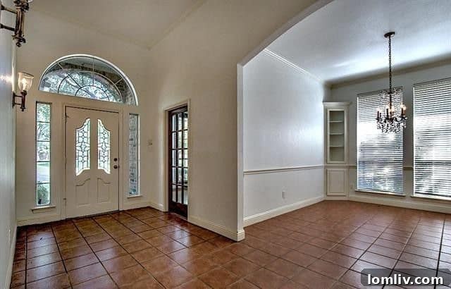 Cozy den with built-in bookcases and a rustic stone fireplace in the charming Forest Hills home