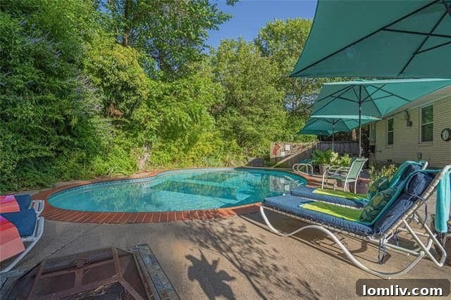Lush backyard oasis with a Parent Trap style pool at 2005 Elmwood Blvd