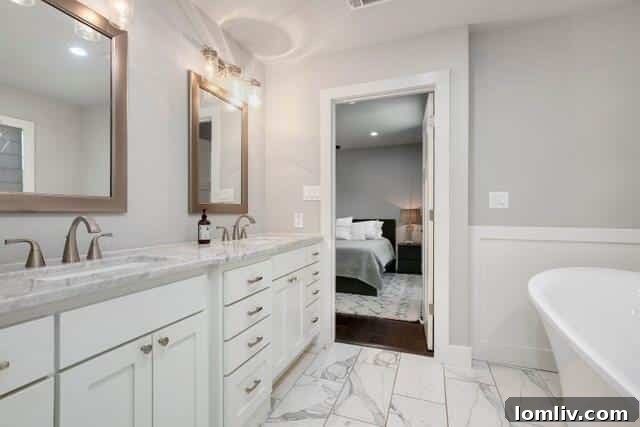 Elegant master bathroom with dual vanities, modern fixtures, and stylish tiling.