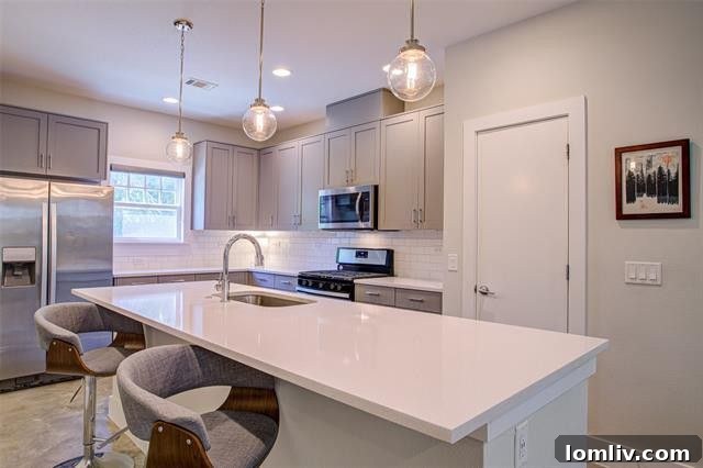 Modern gourmet kitchen with custom quartz countertops, stainless steel appliances, and large island