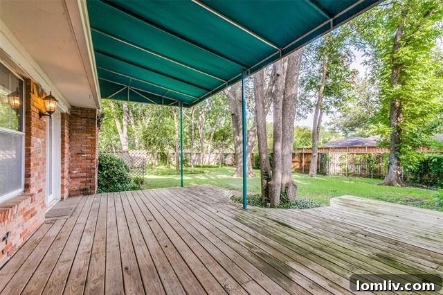 Lush backyard with a private deck and mature trees in a North Dallas home