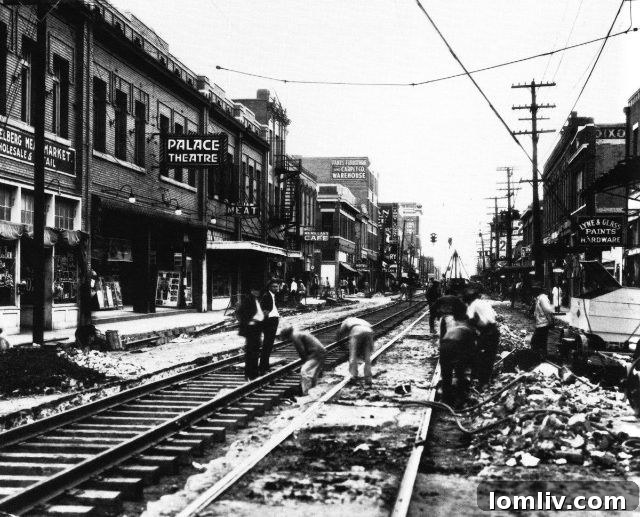 Vintage image of a bustling Deep Ellum street with early automobiles