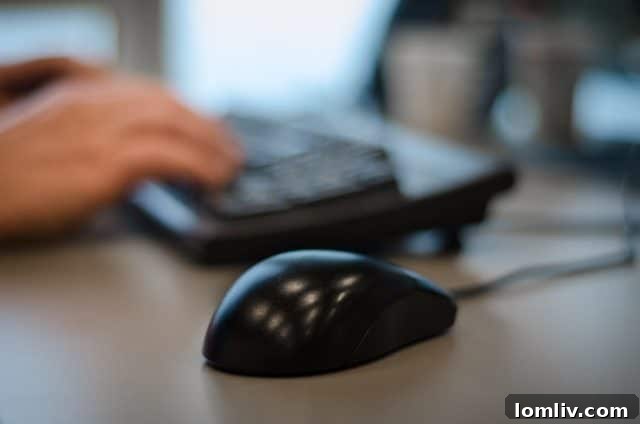 Hands typing on a laptop keyboard at a desk, illustrating modern office work with technology.