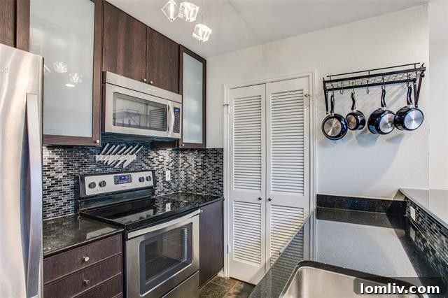 Modern kitchen with breakfast bar and contemporary finishes in the Oak Lawn condo