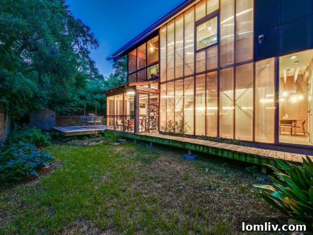 Exterior view of 8643 Groveland Drive, a modern home in Dallas's Little Forest Hills, showcasing its integration with nature and large trees.