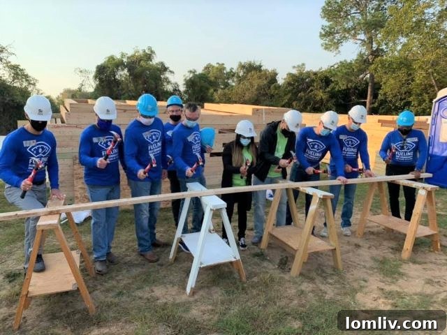 Park Place Dealerships GMs and future Habitat homeowners Rosemary and Wilber Salmeron drive the ceremonial first nails, symbolizing the start of their new home construction.