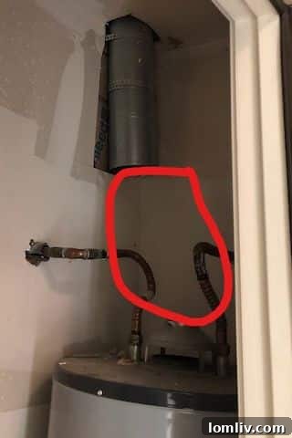 A disconnected flue pipe above a water heater, exposing a safety hazard and potential carbon monoxide leak.