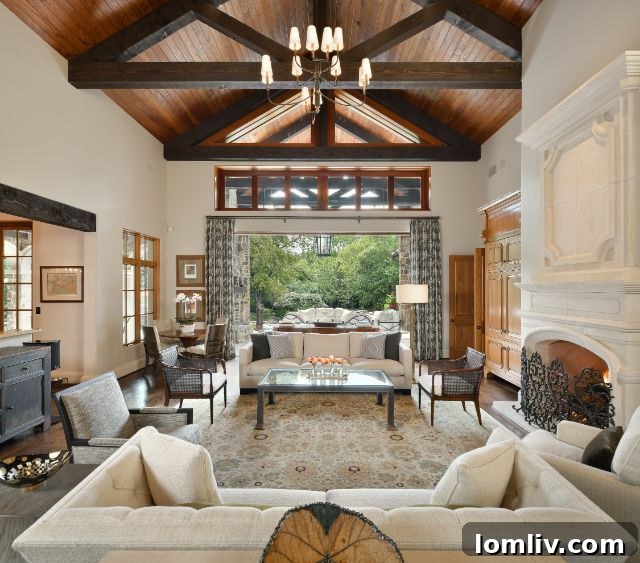 Expansive covered patio with stone fireplace and elegant seating overlooking the tranquil brook