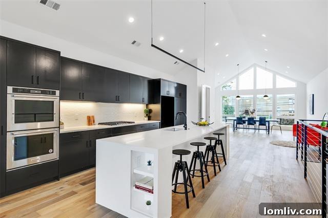 The impressive modern kitchen with a large island, sleek countertops, and high-end appliances, positioned as the heart of the home