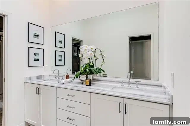 Luxurious bathroom with dual sinks, sleek cabinetry, and polished chrome fixtures in Dallas condo