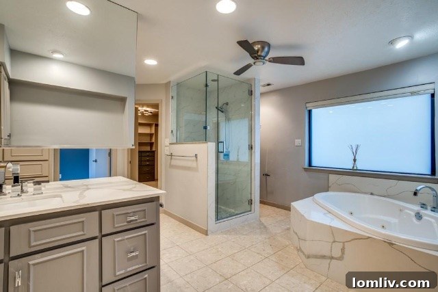 Primary bathroom with modern marble around the bathtub and stylish fixtures