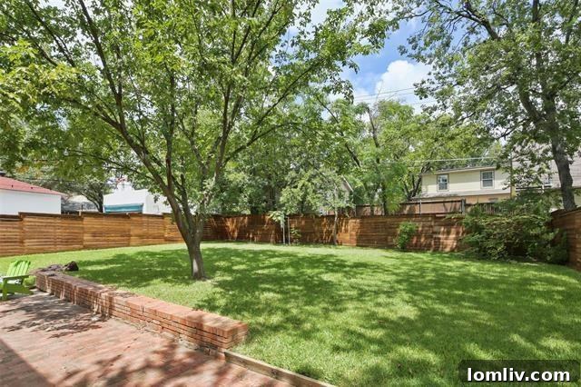 The expansive backyard of the Hollywood Heights home, featuring a large grassy lawn and a brick patio, offering abundant space for outdoor entertaining, relaxation, and the potential addition of a swimming pool.