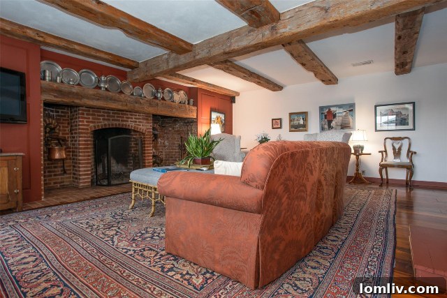 Rustic-inspired fireplace in the family room of 43 Valley Ridge Road, complemented by striking exposed wooden beams on the ceiling.
