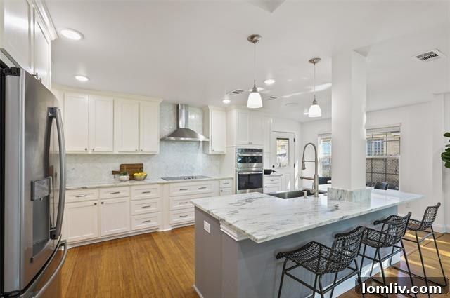 The bright and airy living area of a renovated Dallas home, featuring a cozy fireplace and elegant bamboo wood floors.