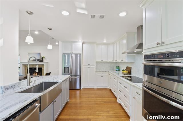 A pristine custom kitchen in a Dallas home, showcasing crisp white cabinets, sleek quartzite counters, and built-in stainless steel appliances.