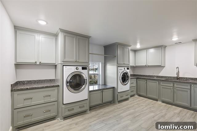 An exceptionally large and bright laundry room with ample counter space, storage, a utility sink, and natural light from a charming window.