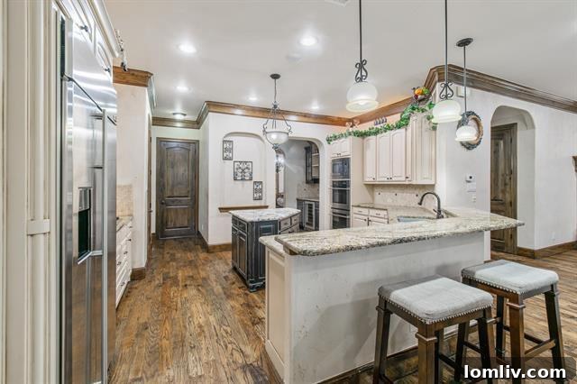 Cozy yet elegant living room with a stone fireplace and comfortable furnishings in a Fort Worth luxury home, ideal for family gatherings.