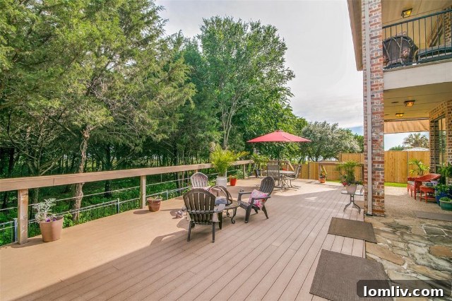 Rear exterior of the custom home at 2365 Lake Forest Drive, revealing the oversized patio and upper deck overlooking the greenbelt