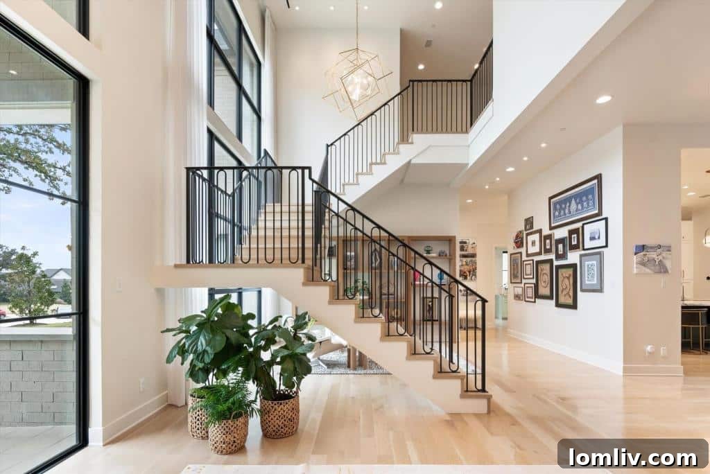 Stylish entryway with floating staircase, chandelier, and natural light at 1501 Moss Lane