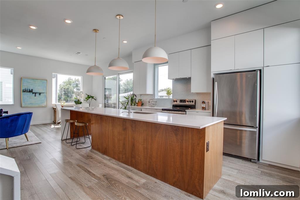 Modern gourmet kitchen featuring quartz waterfall island, premium appliances, and glossy tile backsplash
