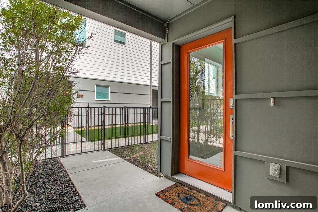 Charming orange front door with modern design, contrasting beautifully with the home's exterior and covered entrance