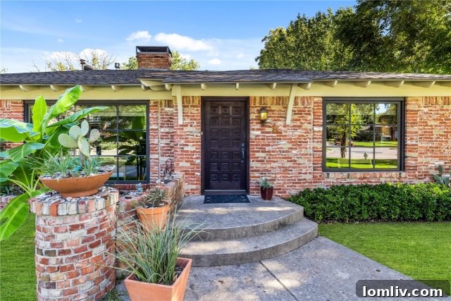 Front facade of a Dilbeck-inspired ranch home with large windows and lush landscaping