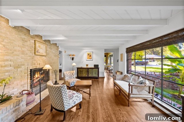 Cozy corner of a living room with a unique stone fireplace, natural light, and comfortable furnishings