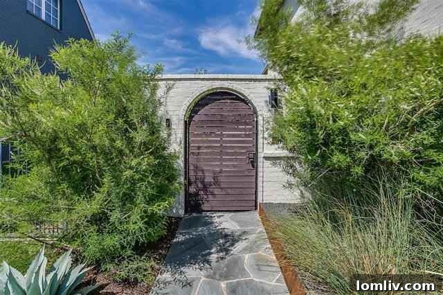 The meticulously landscaped entrance of 2516 Sandage Avenue features water-saving native plants and a stone-paved walkway leading to a discreet, secure entry.