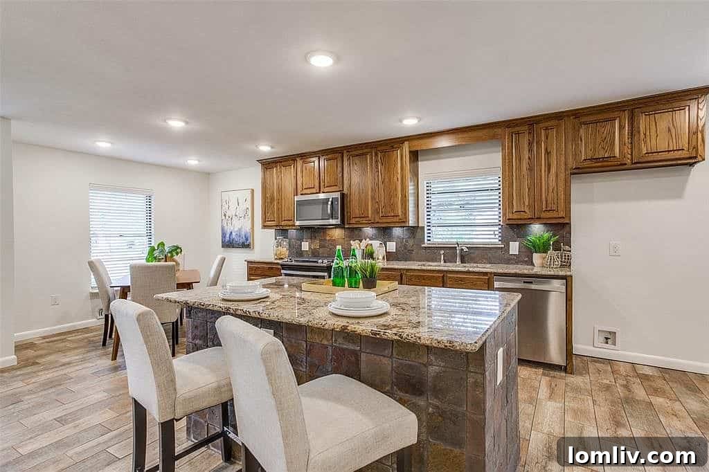 Modern kitchen with oak cabinetry, granite countertops, and stainless steel appliances