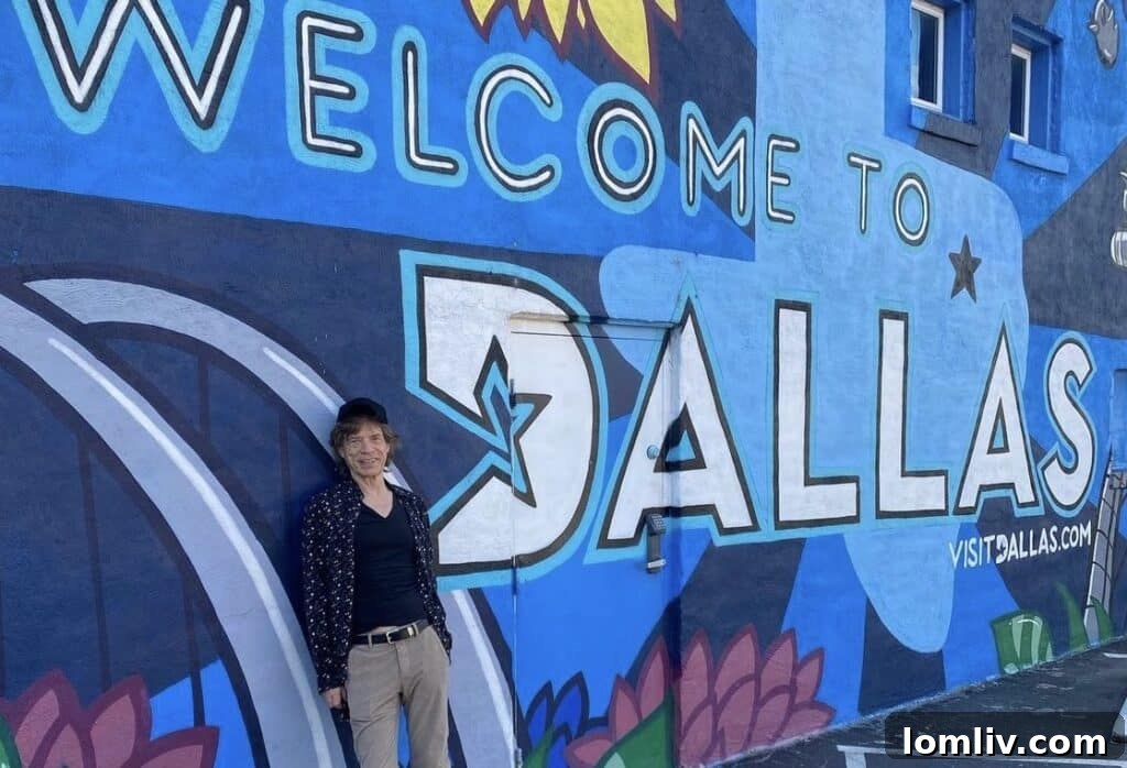 Mick Jagger posing in front of a colorful Deep Ellum mural in Dallas, Texas
