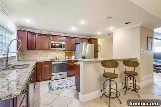 Modern kitchen with stainless steel appliances, an eat-in bar, and glass block window for diffused light and privacy