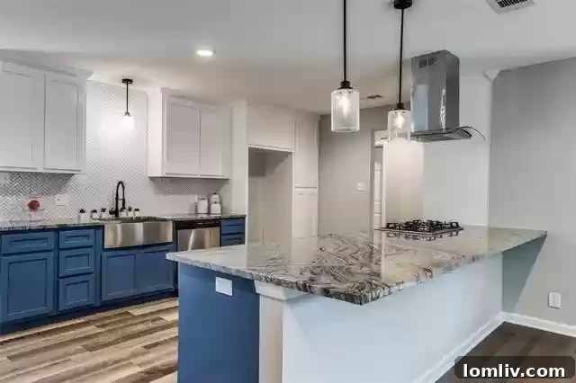 Modern kitchen with bold blue cabinetry, stainless steel appliances, and designer pendant lighting.