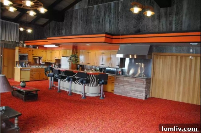 An open-plan living area featuring a large, dated carpet and a sense of vast, underutilized space.