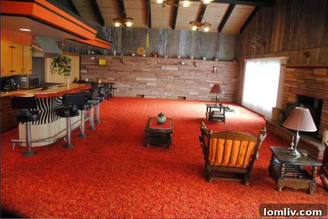 Another perspective of the interconnected living, dining, and kitchen areas, highlighting the continuous carpeting.