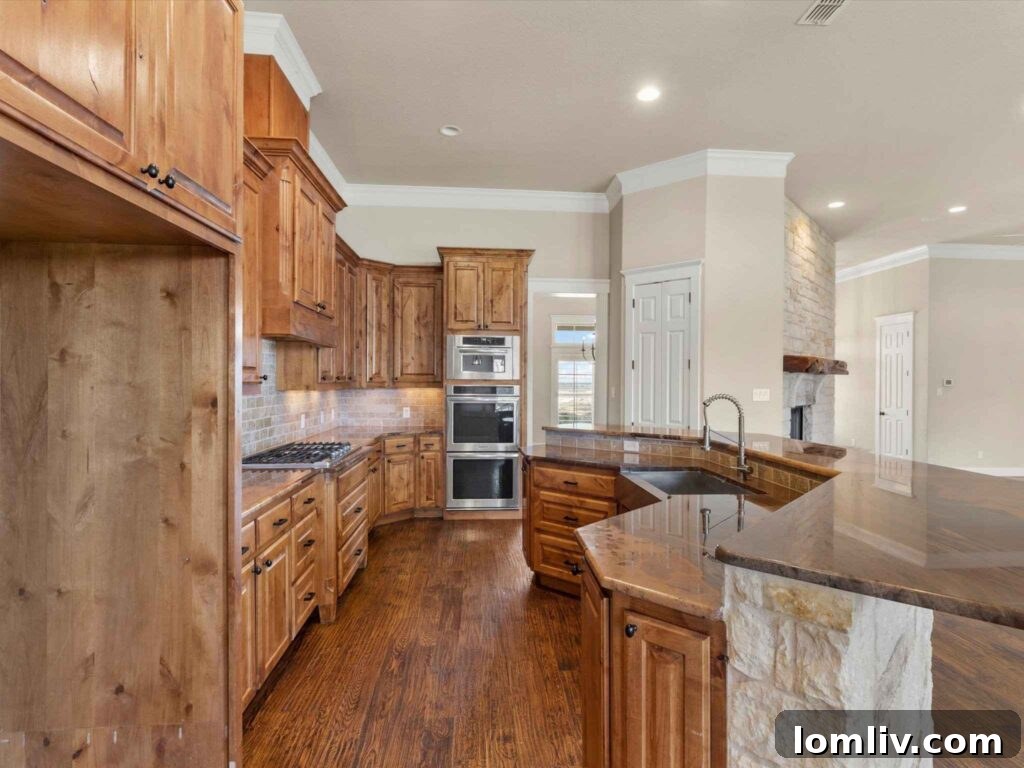 Modern kitchen with large island, gas cooktop, and high-end built-in ovens