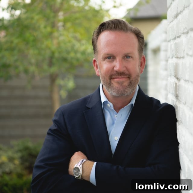Professional portrait of Dan Houchard, acclaimed landscape designer, smiling amidst a vibrant garden backdrop