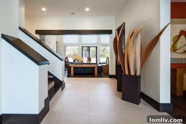 Lake Forest's Singular Gem: Rising Above Zero Lot Line Living 5 Elegant Foyer with Grand Staircase and Natural Light at 7107 Lake Edge