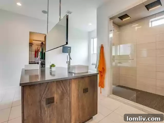 Luxurious primary spa bathroom with dual shower and island vanity