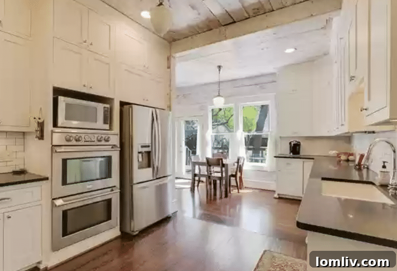 Well-appointed kitchen featuring stacked cabinets and modern stainless steel appliances within a historic setting.