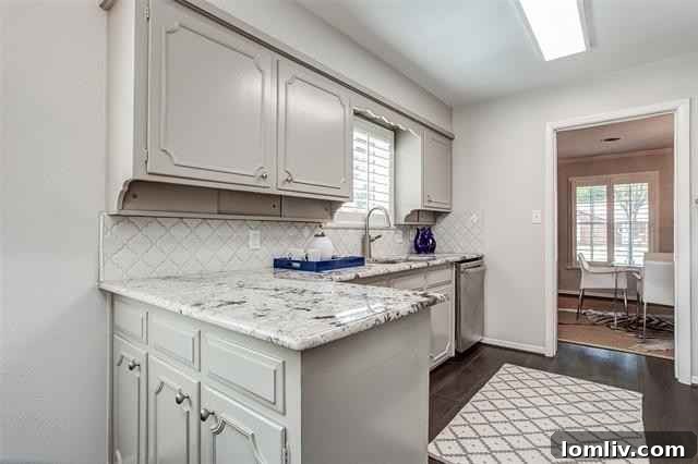 Updated Kitchen with Gas Cooktop, Granite Countertops, and White Cabinetry