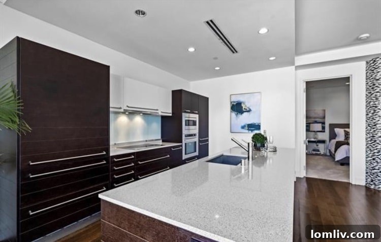 Sleek kitchen design with a large island in a Dallas luxury condominium.