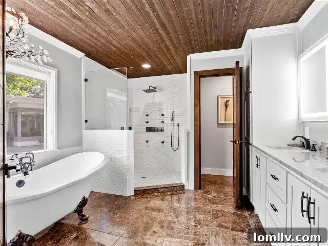 Luxurious primary bathroom with stained wood panel ceiling and crisp white finishes