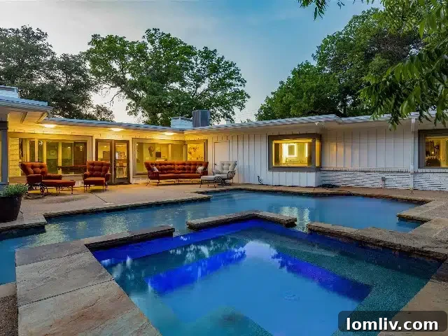 Inviting backyard pool and spa surrounded by lush landscaping, perfect for summer