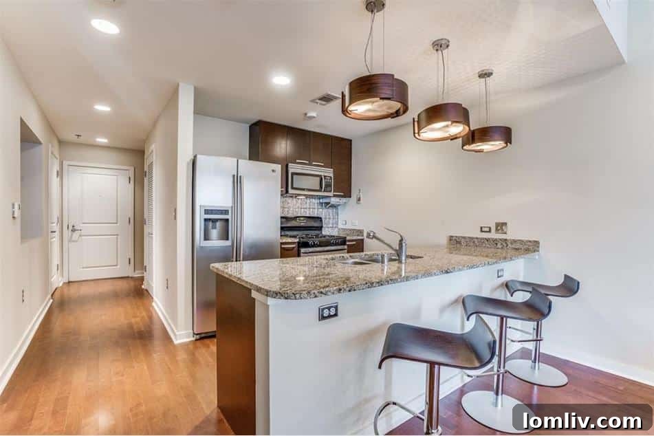Urban Elegance Redefined: A Highrise Haven in the City 4 The sleek and modern kitchen in a Dallas high-rise condo, featuring updated appliances and designer lighting.