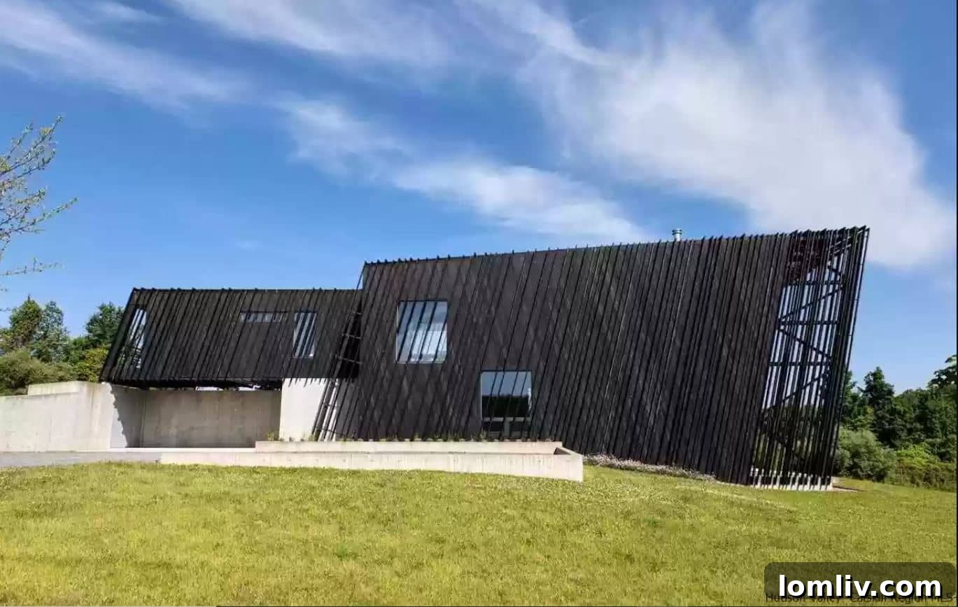 Exterior view of a contemporary architectural marvel in Ancram, New York, nestled within expansive acreage.