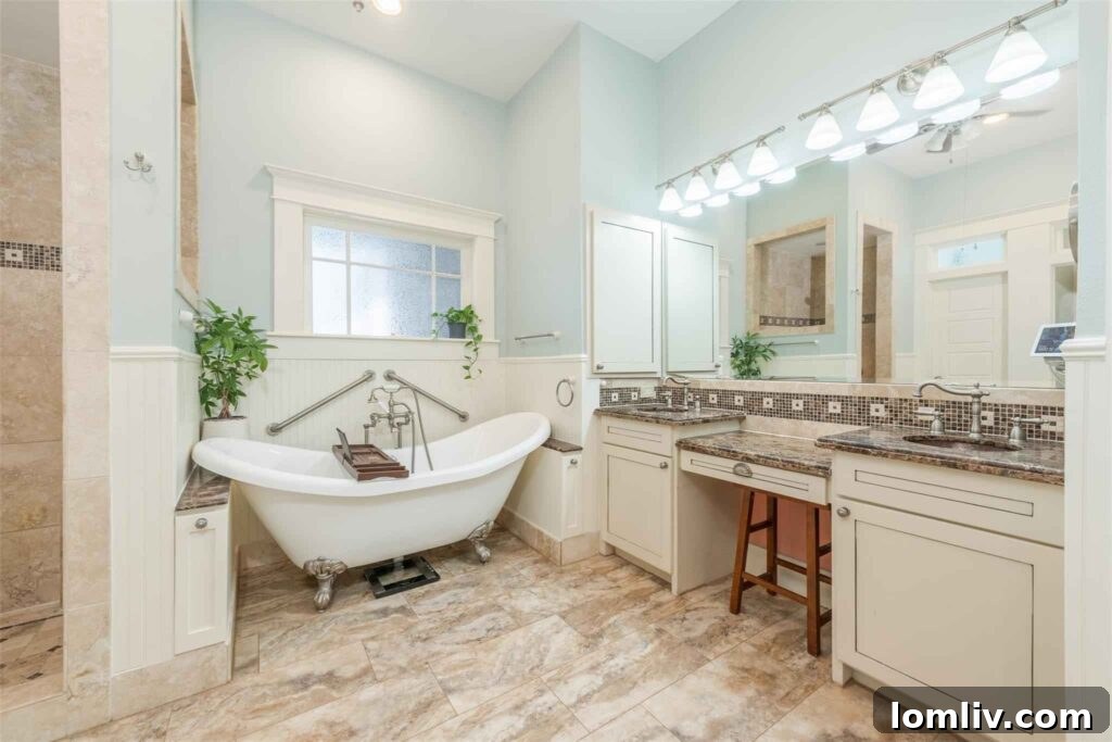 Luxurious master bathroom with twin vanities and travertine floors