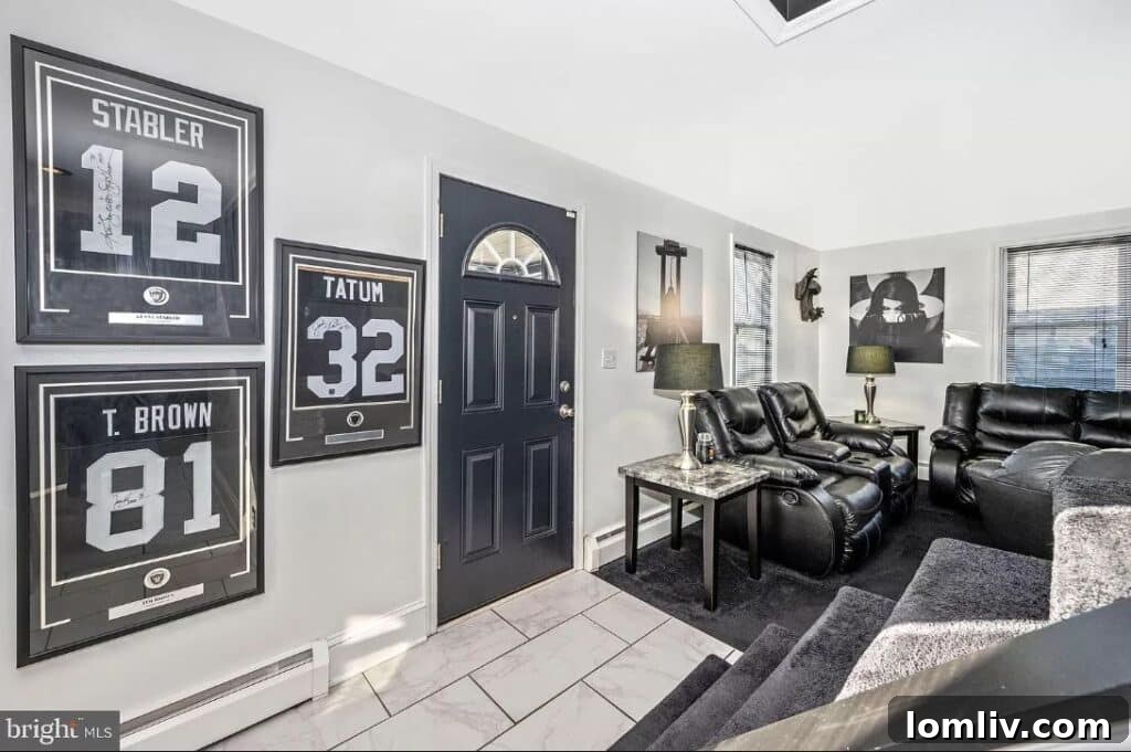 Interior view of a living room with dark Raiders-themed decor, including black and silver elements