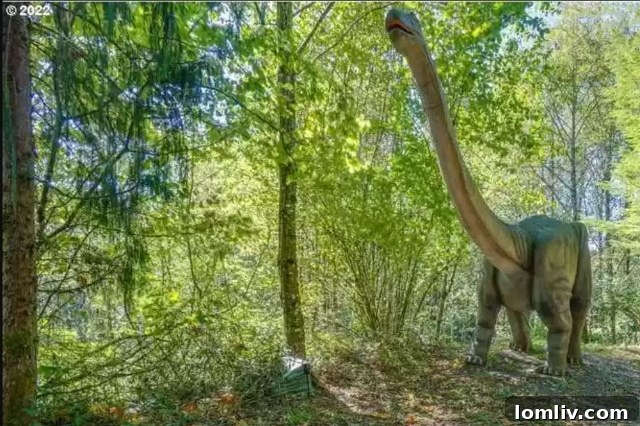 Close-up of a Velociraptor dinosaur sculpture in a cage outside the themed house